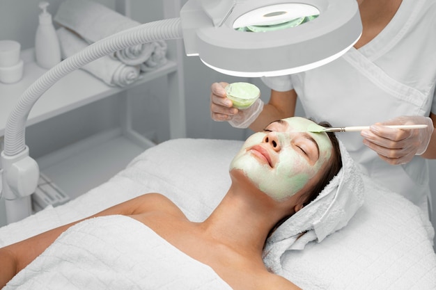 Esteticista aplicando mascarilla en clienta