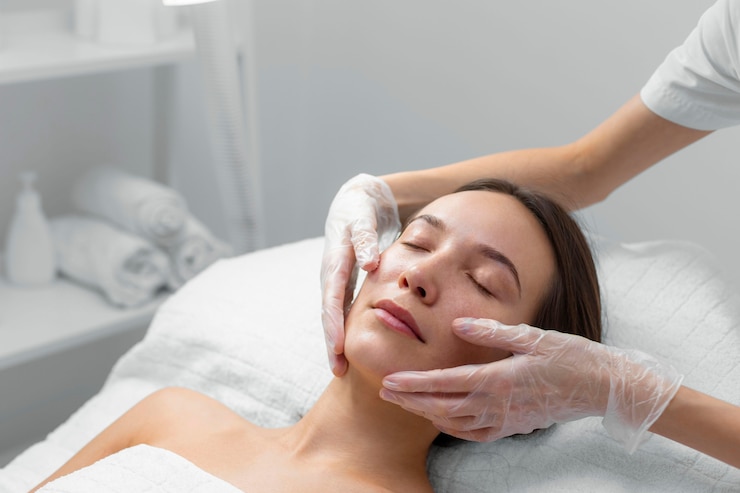 Foto gratuito esteticista con clienta en el salón de rutina de cuidado facial