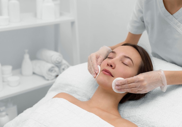 Foto gratuito esteticista con clienta en el salón de rutina de cuidado facial
