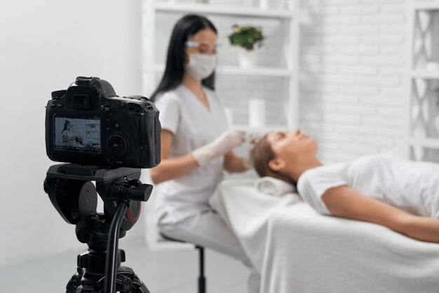 Esteticista haciendo un procedimiento especial para el cabello en la cámara