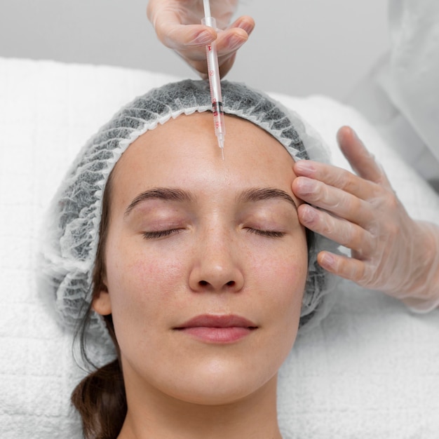 Esteticista haciendo relleno de inyección en clienta