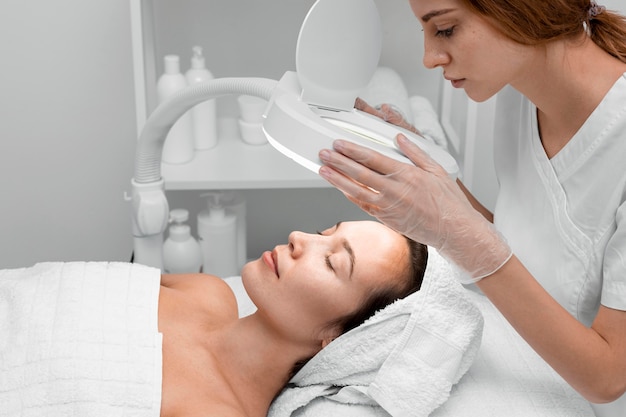 Foto gratuita esteticista haciendo rutina de belleza facial para clienta