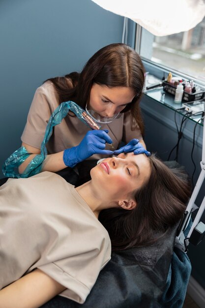 Esteticista haciendo un tratamiento de cejas para su clienta