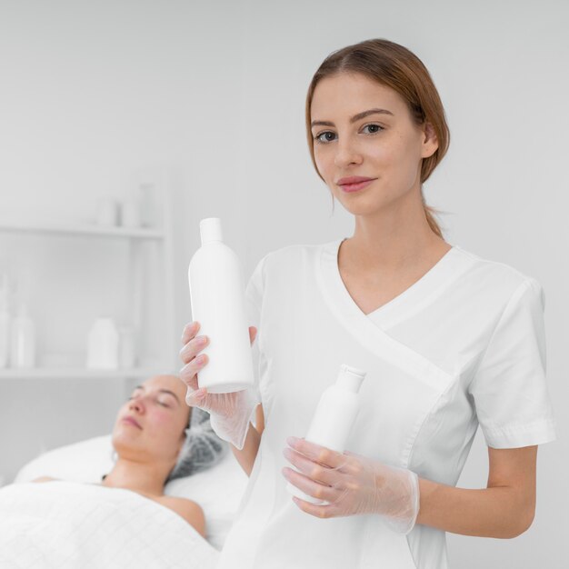 Esteticista con loción para clienta