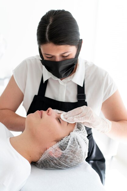 Esteticista realizando un procedimiento de microblading