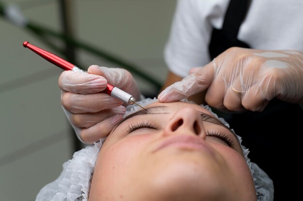 Esteticista realizando un procedimiento de microblading