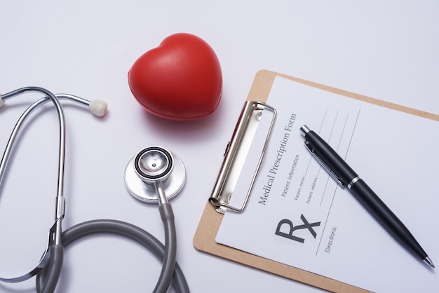 Foto gratuita estetoscopio con corazón. estetoscopio y corazón rojo sobre mesa de madera. concepto de seguro de vida hospitalario. idea del día mundial de la salud del corazón. concepto de medicina o farmacia. formulario médico vacío listo para ser utilizado.