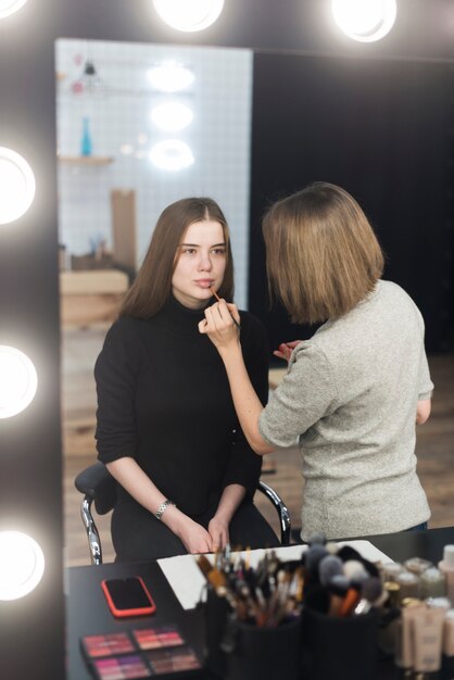 Estilista aplicando maquillaje en modelo