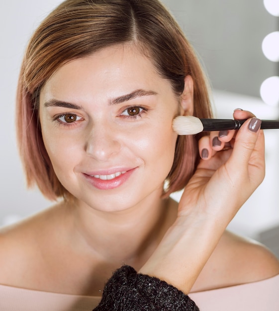 Foto gratuita estilista aplicando maquillaje en modelo