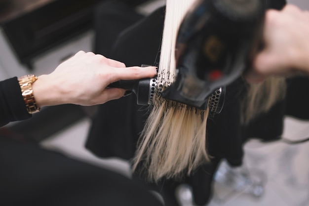 Estilista de la cosecha que fija el pelo con el cepillo