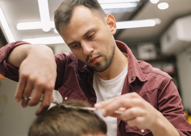 Foto gratuita estilista dando un corte de pelo a un cliente