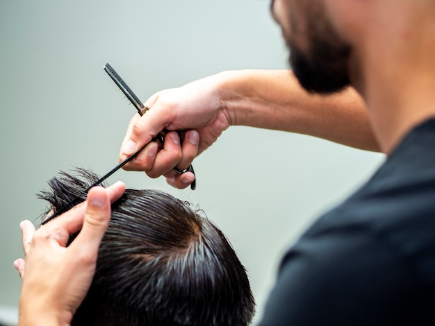 Estilista midiendo la longitud del cabello del cliente