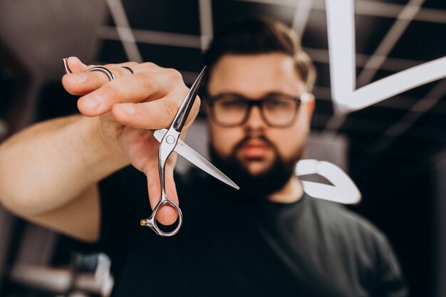 Estilista profesional con herramientas de barbero de cerca