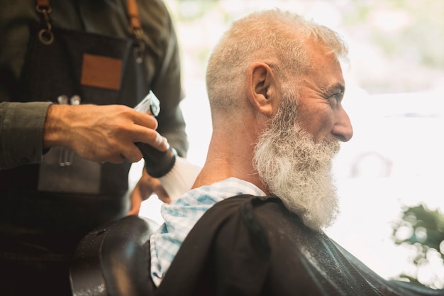 Estilista que corrige el corte de pelo en el salón