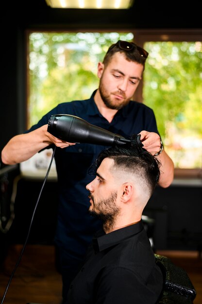 Estilista secando el cabello de su cliente