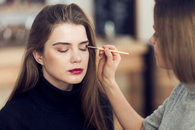 Estilista trabajando con hermosa modelo