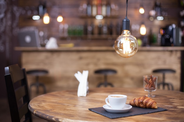Estilo de cafetería parisina con sabroso café servido en mesa de madera. Diseño de cafetería.