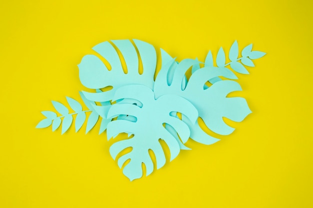 Estilo de corte de papel de hojas de monstera sobre fondo amarillo