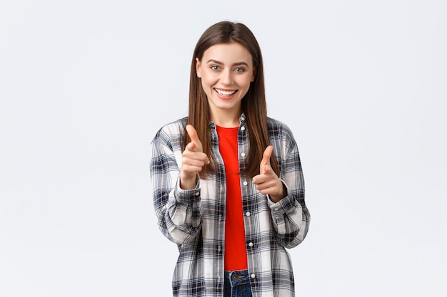 Estilo de vida, diferentes emociones, concepto de actividades de ocio. Chica guapa joven entusiasta y feliz en traje casual apuntando con el dedo a la cámara, gesto de felicitación o te pillé, eligiéndote