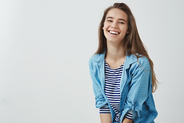 Estilo de vida feliz, concepto de bienestar. Encantadora y despreocupada mujer atractiva y sonriente riendo a carcajadas sintiéndose afortunado optimista, teniendo unas vacaciones increíbles disfrutando de un tiempo libre, divirtiéndose