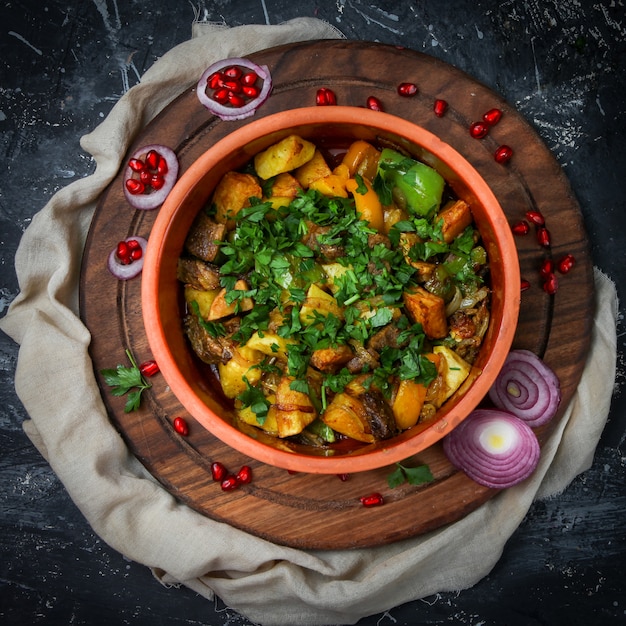 Foto gratuita estofado de carne en un plato con papas, pimiento, hierbas, cebolla, granada