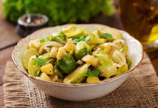 Estofado de coles de col de Bruselas, manzanas y puerros en un tazón. Menú dietético