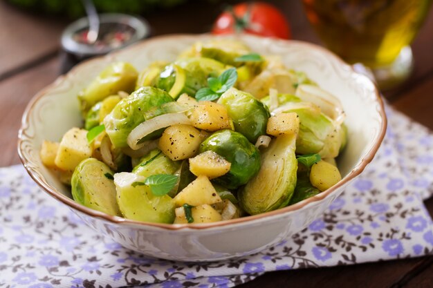 Estofado de coles de col de Bruselas, manzanas y puerros en un tazón. Menú dietético