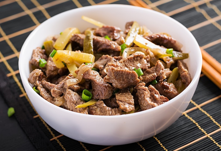 Foto gratuito estofado de ternera, trozos de ternera guisados en salsa de soja con especias con pepino encurtido al estilo asiático.