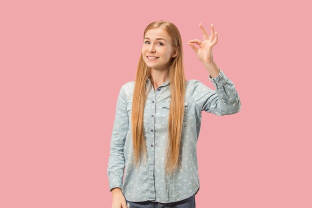 Estoy bien. Mujer de negocios feliz, firmar ok, sonriendo, aislado sobre fondo de estudio rosa de moda. Hermoso retrato femenino de medio cuerpo. Mujer emocional. Las emociones humanas, el concepto de expresión facial. Frente