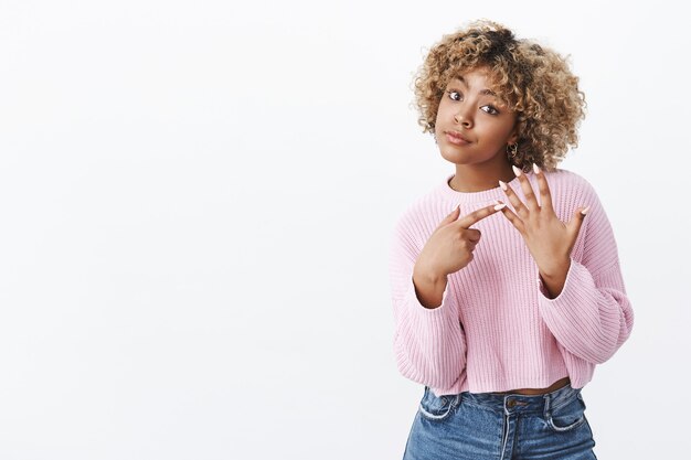 Estoy esperando propuesta. Irritada mujer afroamericana asertiva con cabello rubio enfurruñado y mirando a la cámara cuestionada levantando la mano y señalando con el dedo pidiendo anillo queriendo casarse