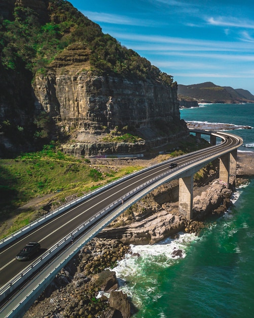 Foto gratuita una estrecha carretera con curvas con coches junto a montañas verdes