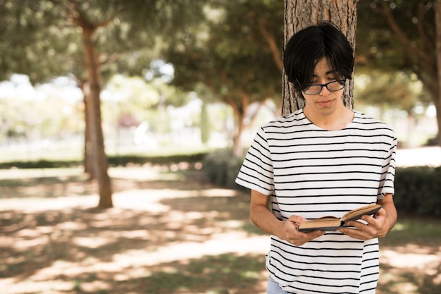 Estudiante adolescente asiático con libro abierto