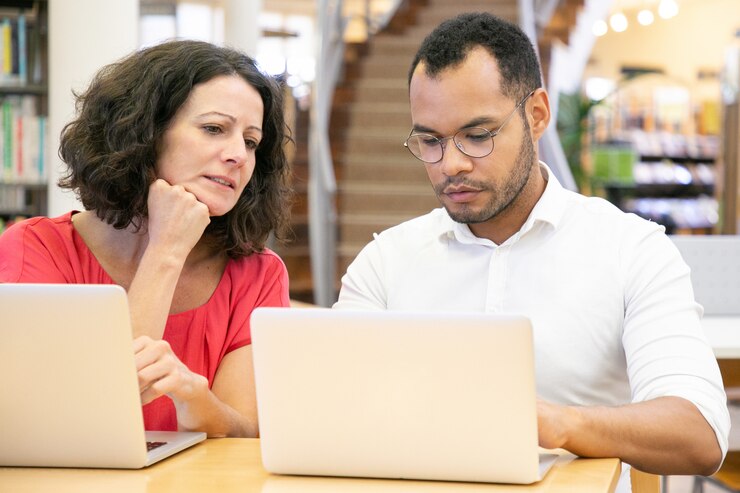 Foto gratuito estudiante adulta mirando el monitor de su compañero de universidad