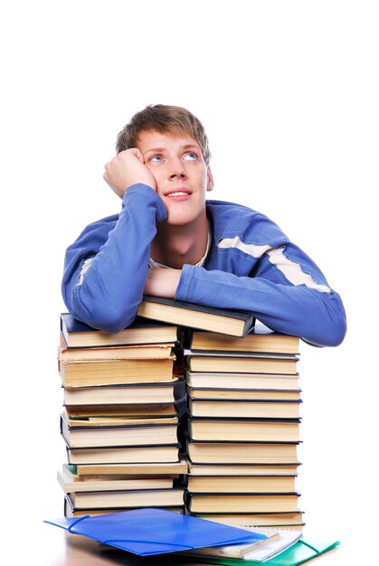 Estudiante adulto joven anotó en un montón de libros mirando hacia arriba y pensando.