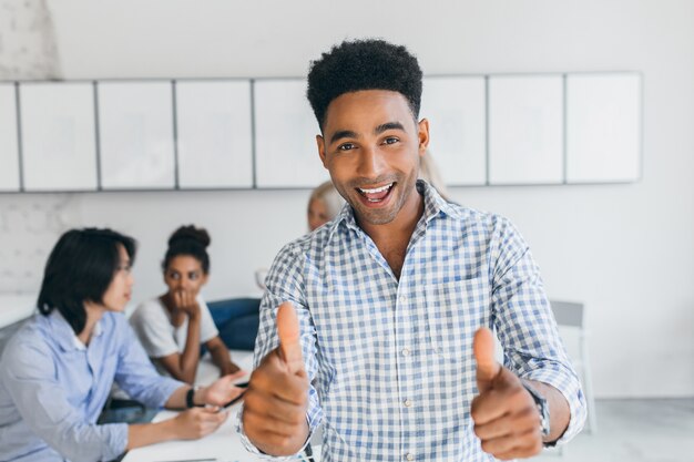 Estudiante africano aprobó exámenes y se divirtió con sus compañeros de universidad. Trabajadores de oficina internacional discutiendo sobre los nuevos objetivos de la empresa.