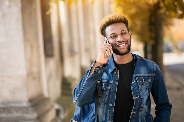 Estudiante afroamericano con teléfono