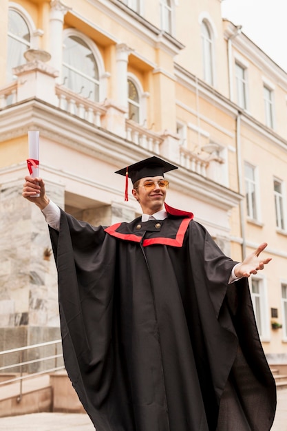 Foto gratuita estudiante de ángulo bajo celebrando