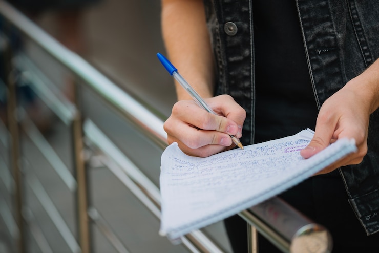 Foto gratuito estudiante anónimo tomando notas
