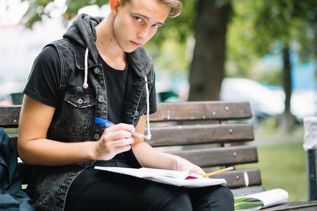 Estudiante en el banco con blocs de notas