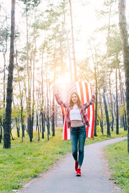 Estudiante con la bandera de Estados Unidos bajo el sol