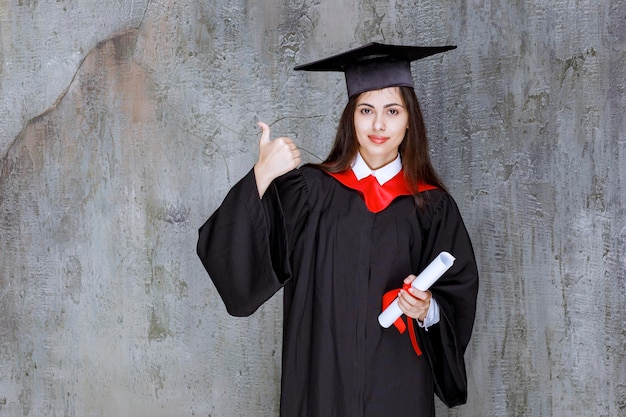 Estudiante con bata con certificado de graduación de la universidad. foto de alta calidad