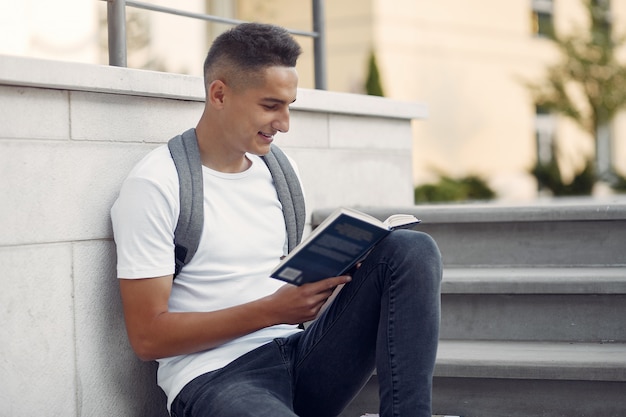 Estudiante en un campus universitario con un libro