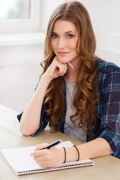 Estudiante. Chica atractiva junto a la mesa