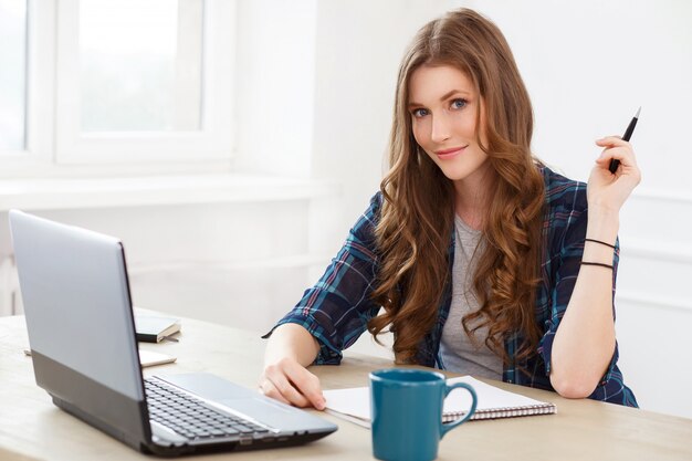 Estudiante. Chica atractiva junto a la mesa