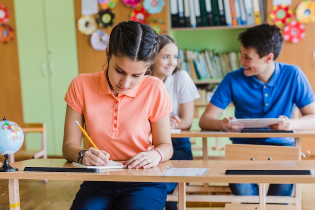 Estudiante concentrada escribiendo en clase