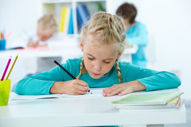 Estudiante concentrada escribiendo en su cuaderno