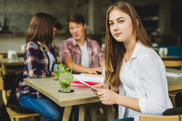 Estudiante confidente con la tableta en café