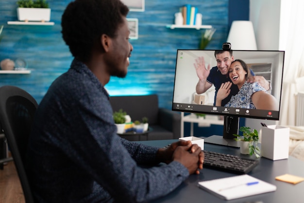 Estudiante disfrutando de pasar tiempo con amigos remotos discutiendo ideas de proyectos de gestión durante la conferencia de la reunión de videollamada en línea. Hombre tiene llamada de videoconferencia virtual durante el bloqueo por coronavirus