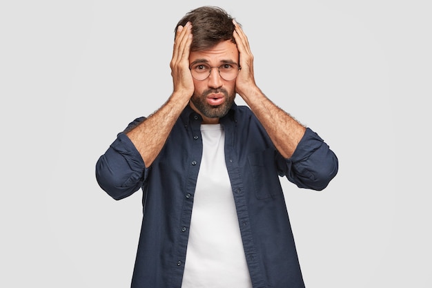 Foto gratuita estudiante disgustado estresante posando contra la pared blanca