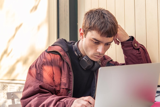 Un estudiante estudia usando una computadora portátil un estudiante masculino estudiando en línea